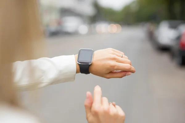 Woman using smartwatch on the street — Stock Photo, Image