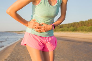 Woman runner having stomach cramps clipart