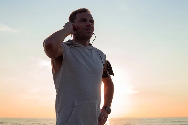 Homem após homem correr na praia de pé ao pôr do sol — Fotografia de Stock