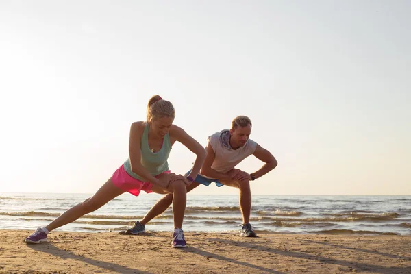 Runners stretching by the sea after workout — Stock Photo, Image