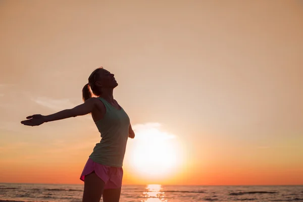 Happy and healthy woman standing in sunset — Stock Photo, Image