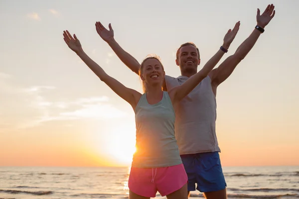 Fit couple stretching in sunset — Stock Photo, Image