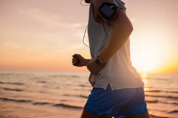 Man running on the beach and listening music — Stock Photo, Image