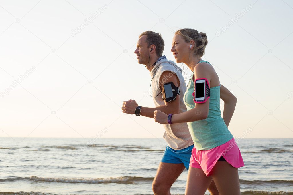 Couple running on the beach and listening music