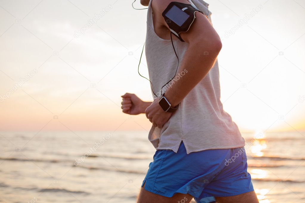 Man running with music player and smartwatch on his wrist