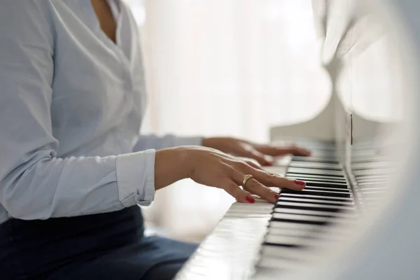 Vrouw spelen witte piano — Stockfoto