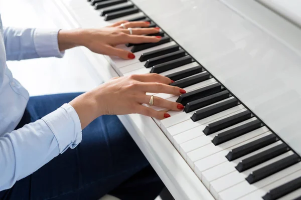 Woman playing white piano — Stock Photo, Image