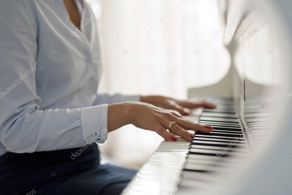 Woman playing white  piano