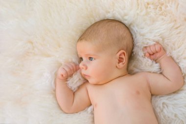 Beyaz tüylü arka plan üzerinde uyuyan erkek bebek