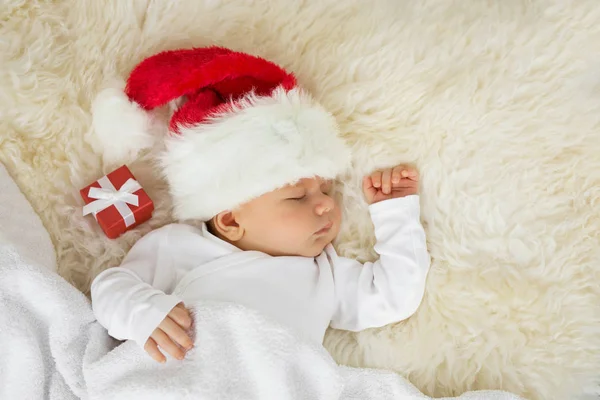 Bambino che dorme con cappello di Natale e confezione regalo — Foto Stock