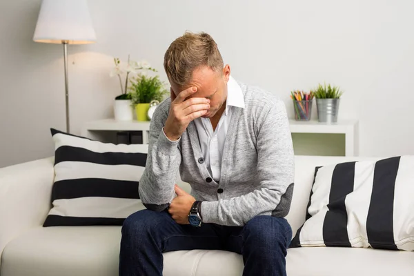 Homme déprimé assis sur le canapé — Photo