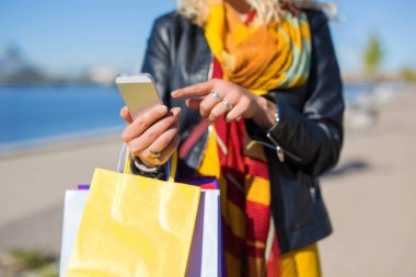 Alışveriş torbaları Smartphone'da chat yapan kadınla
