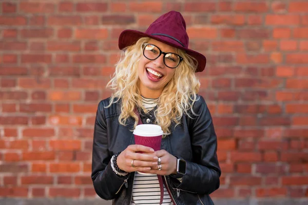 Kobieta stojąc z filiżanki kawy i uśmiechając się — Zdjęcie stockowe