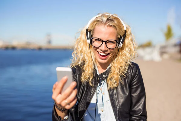 Kadın onun smartphone cep telefonu ile müzik dinlemek — Stok fotoğraf