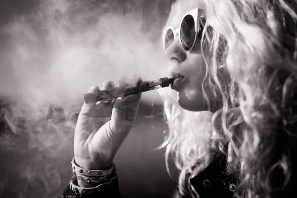 Чорно-біла фотографія жінки, яка курить електронну сигарету — стокове фото