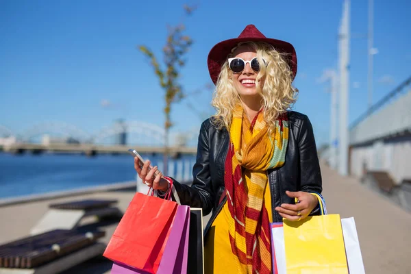 Kvinna med telefonen i hennes händer efter shopping — Stockfoto