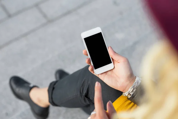 Mujer sentada afuera y usando smartphone — Foto de Stock