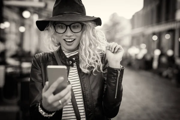 Zwart-wit foto van vrouw kijkt haar telefoon — Stockfoto