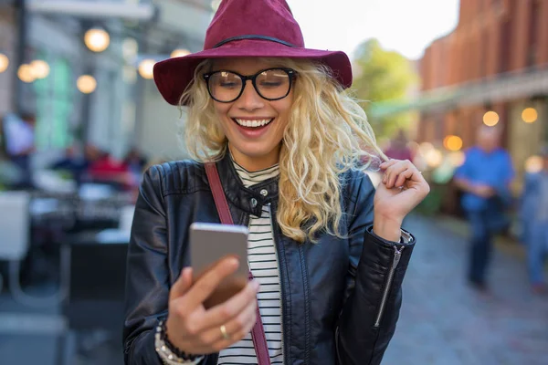 Glad och rolig kvinna som tittar på hennes telefon — Stockfoto