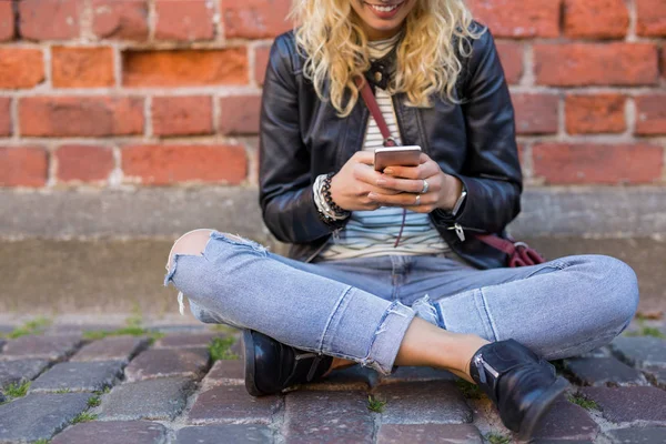 Hipster sitter på marken och använda telefon — Stockfoto