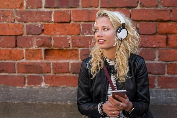 现代女性在她的智能手机上听音乐 — 图库照片
