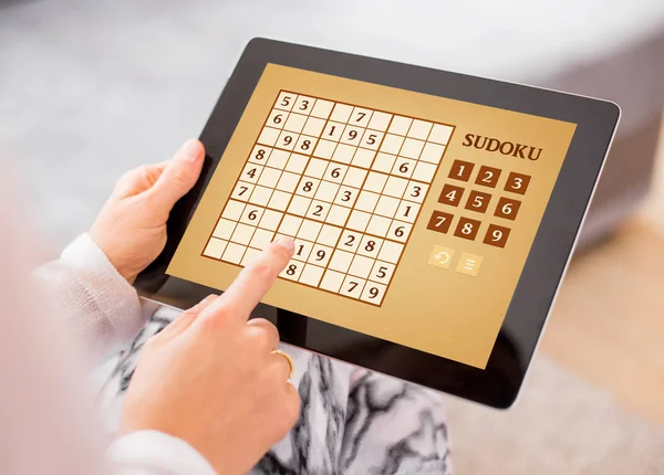 Vrouw Sudoku spelen op tablet pc — Stockfoto