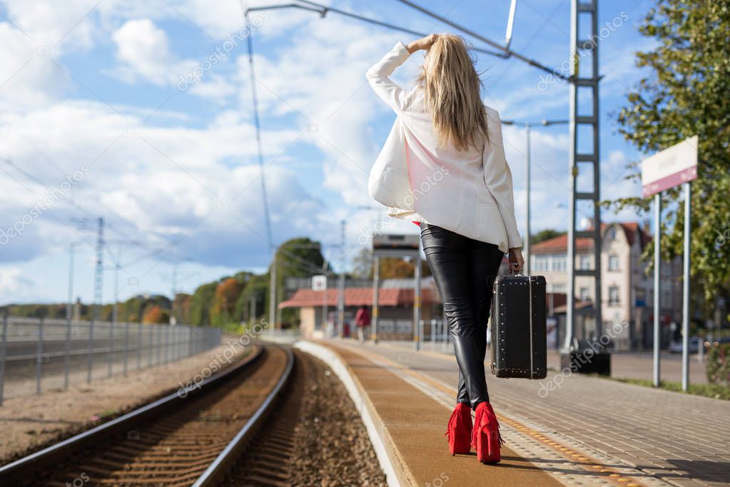 Woman with suitcase waiting in station