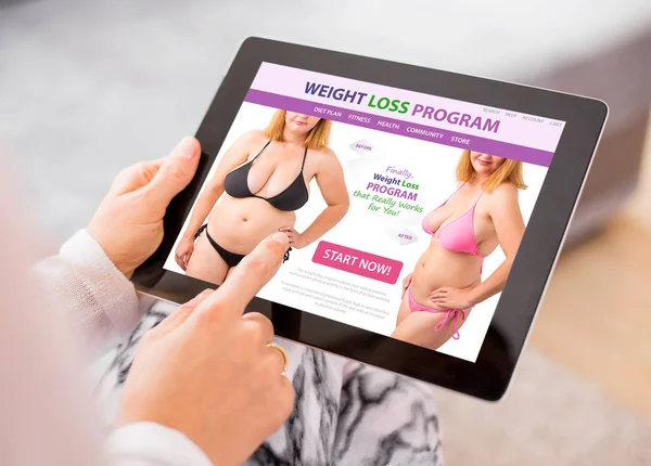 Woman reading about weight loss on tablet computer — Stock Photo, Image