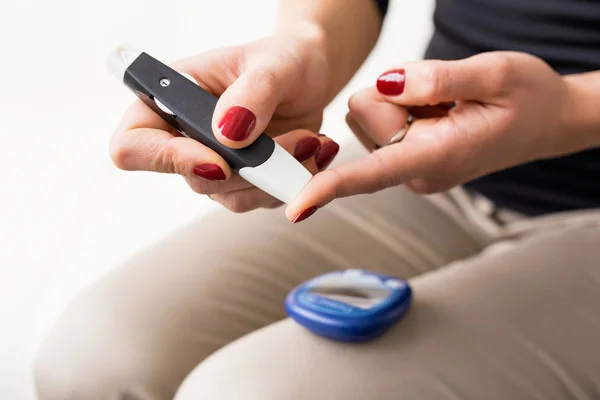 Person using diabetes kit on her finger — Stock Photo, Image