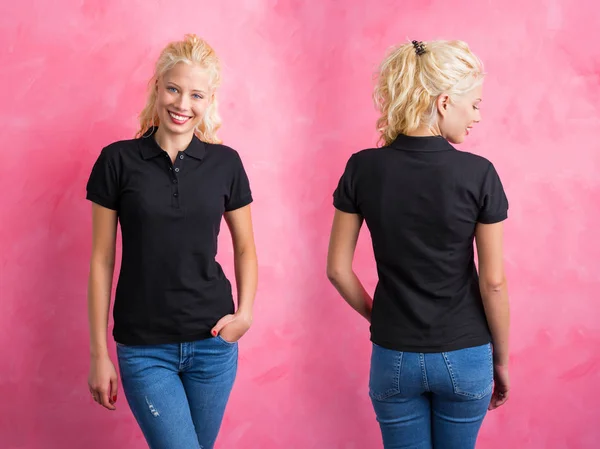 Mulher de polo preto T-shirt sobre fundo rosa — Fotografia de Stock