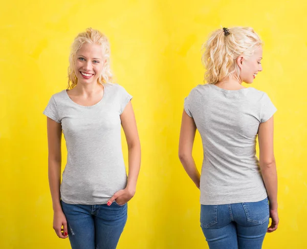 黄色の背景に灰色のラウンド ネック t シャツの女性 — ストック写真