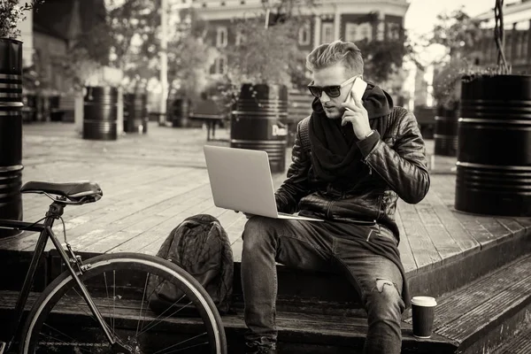 Černobílý obrázek bokovky, pracují na notebooku a mluvil po telefonu — Stock fotografie