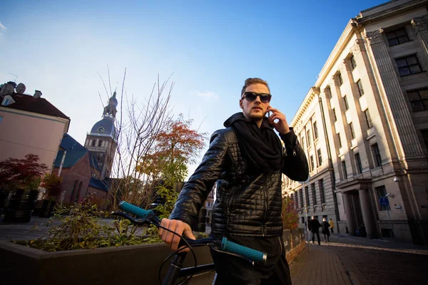 Uomo con bicicletta in città che parla al telefono — Foto Stock