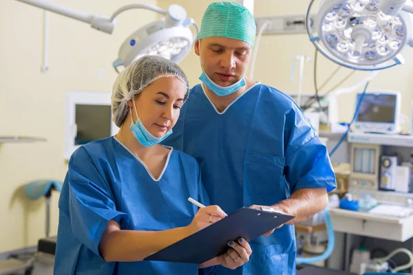 Médico y enfermera revisando el papeleo — Foto de Stock