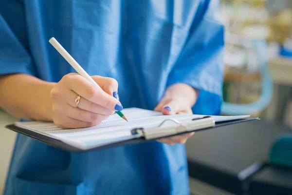 Médico que assina papéis médicos — Fotografia de Stock