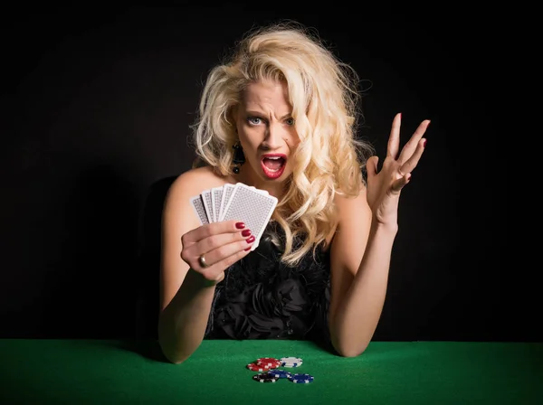 Женщина в шоке от своей ужасной колоды в покер — стоковое фото