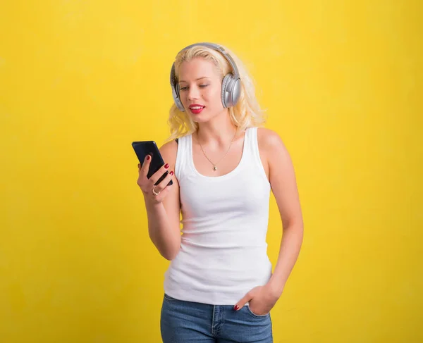 Женщина слушает музыку на гарнитуре со своего телефона — стоковое фото