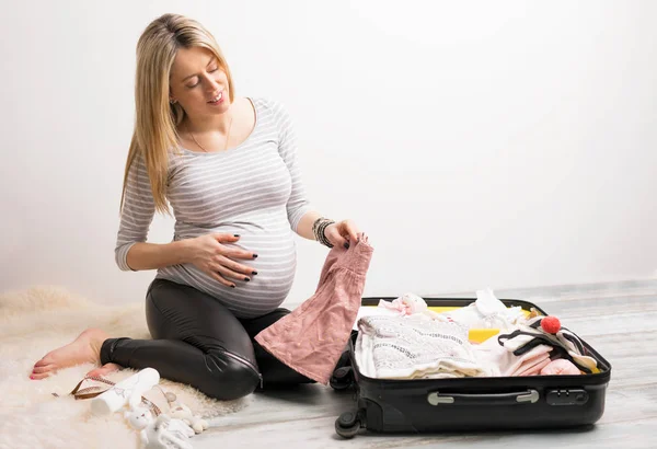Vrouw verpakking babykleding — Stockfoto