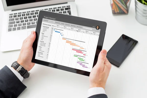 Uomo d'affari guardando grafico Gantt sul computer tablet — Foto Stock