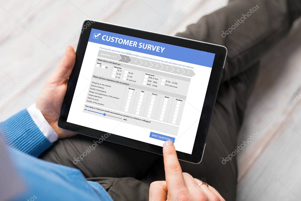 Man filling customer survey form on tablet computer
