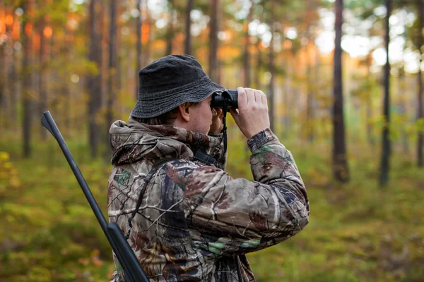 Jäger beobachtet Wald mit Fernglas — Stockfoto
