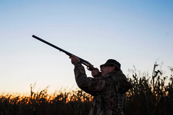 Hunter apontando para patos ao pôr do sol — Fotografia de Stock