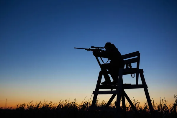 Hunter em torre de vigia ao entardecer — Fotografia de Stock