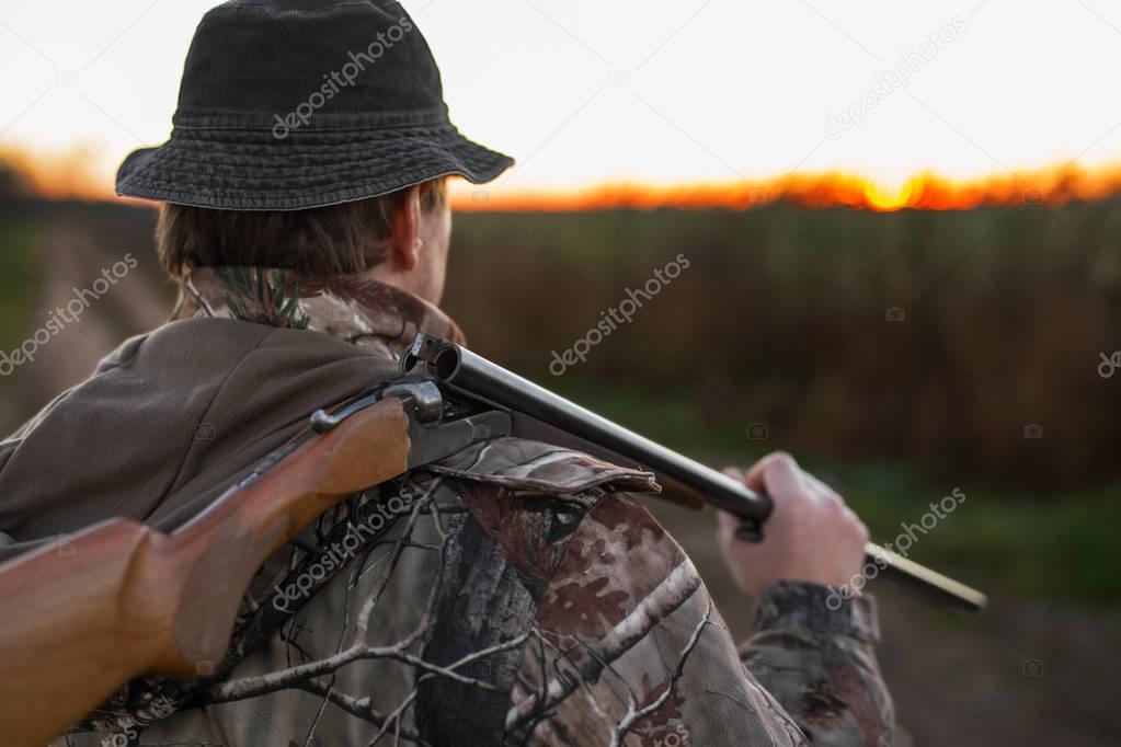 Hunter with rifle over his shoulder