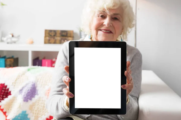 Старшая женщина показывает планшетный компьютер — стоковое фото