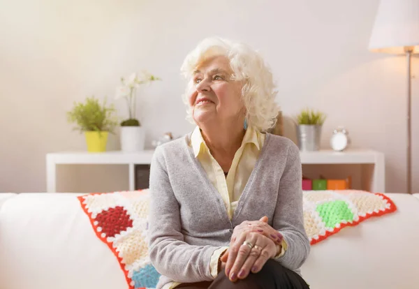 Oma tagträumt, während sie auf der Couch sitzt — Stockfoto