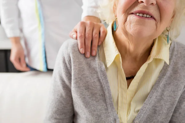 Медсестра тримає руку на плечі літніх людей — стокове фото