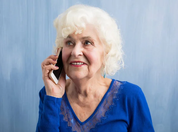 Äldre kvinna pratar i mobiltelefon — Stockfoto