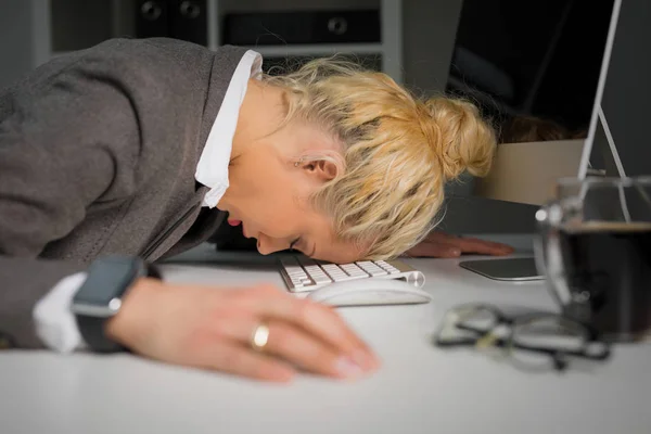 Mujer durmiendo en el teclado de las computadoras en la oficina — Foto de Stock