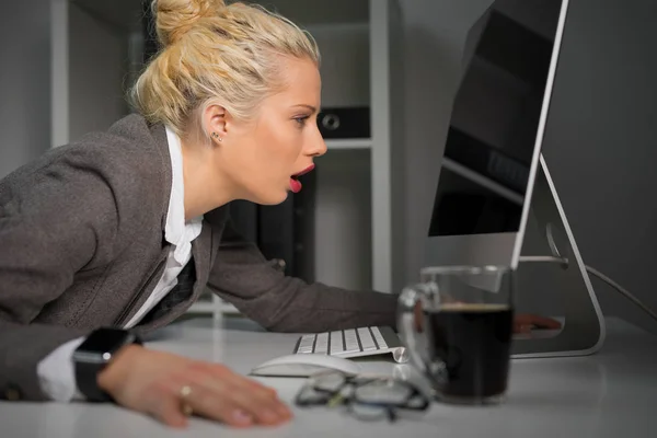 Mulher exausta e cansada olhando para a tela do computador muito perto — Fotografia de Stock